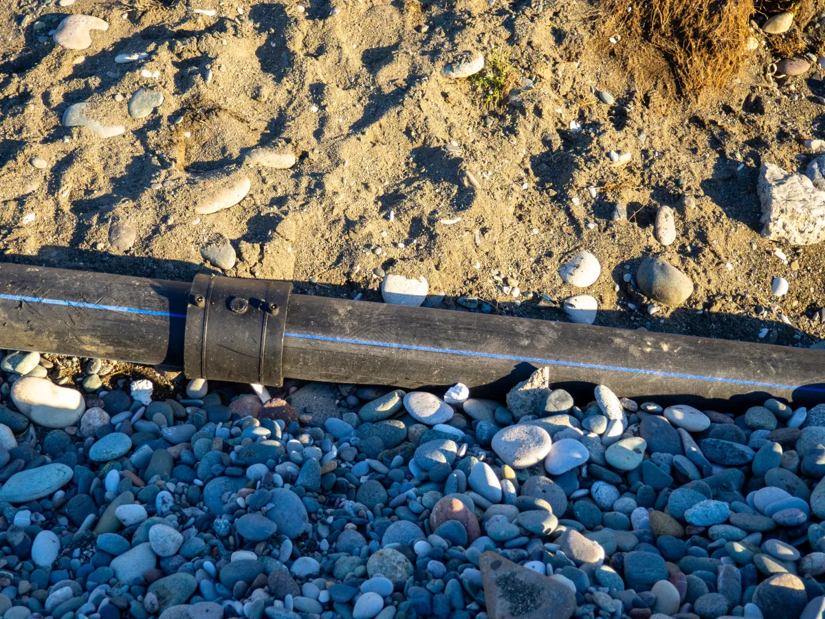Drainage pipe bedded in gravel and soil during a culvert installation in central Indiana