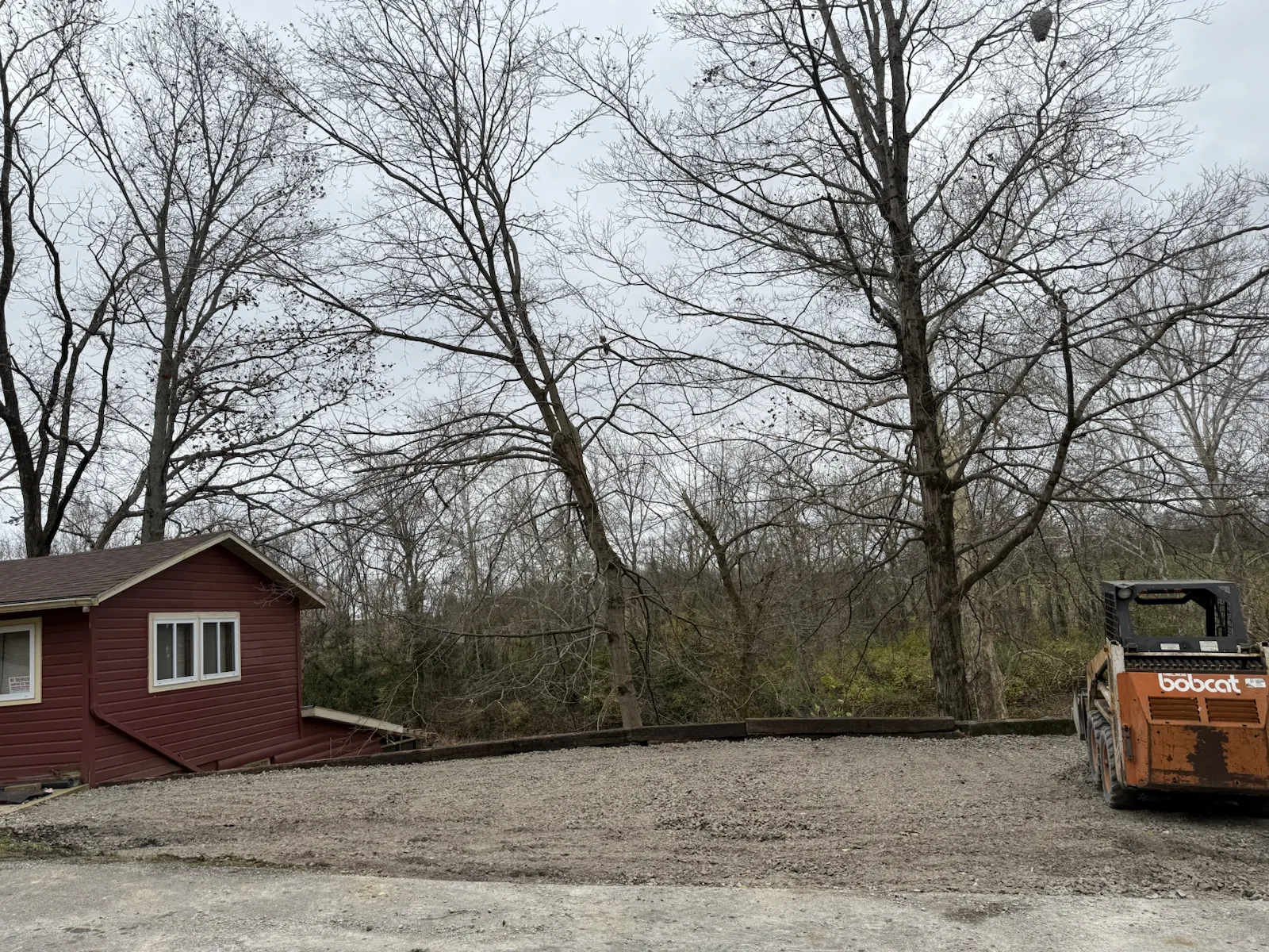 Wide finished gravel pad beside a red lakeside cabin in central Indiana (photo 2)