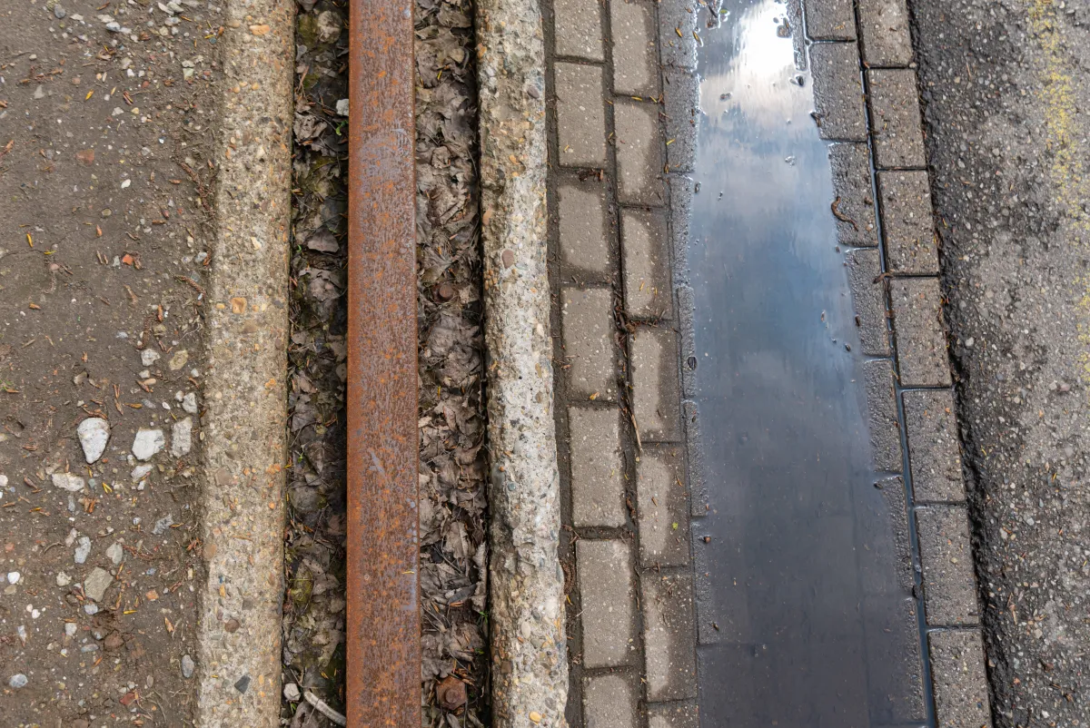 Roadside drainage channel moving water along a paved edge in central Indiana