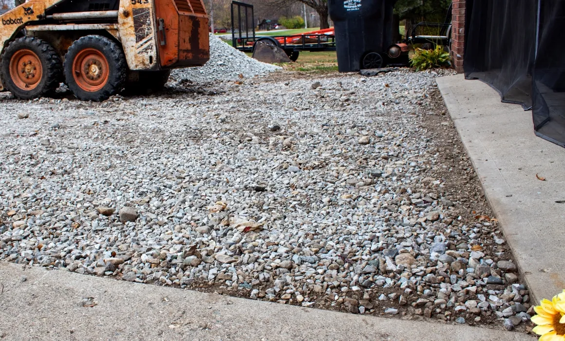 Skid steer spreading gravel on a driveway in Morristown, Indiana