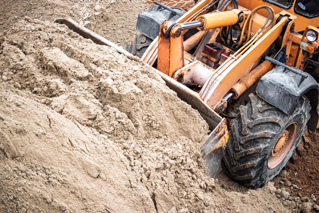 Wheel loader moving earth and gravel during site grading in central Indiana